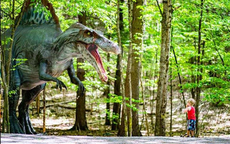 Programmed animatronic dinosaur movement on a park trail