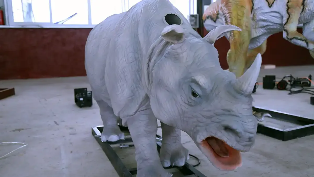 Life-size animatronic white rhino with mouth open and ears flared