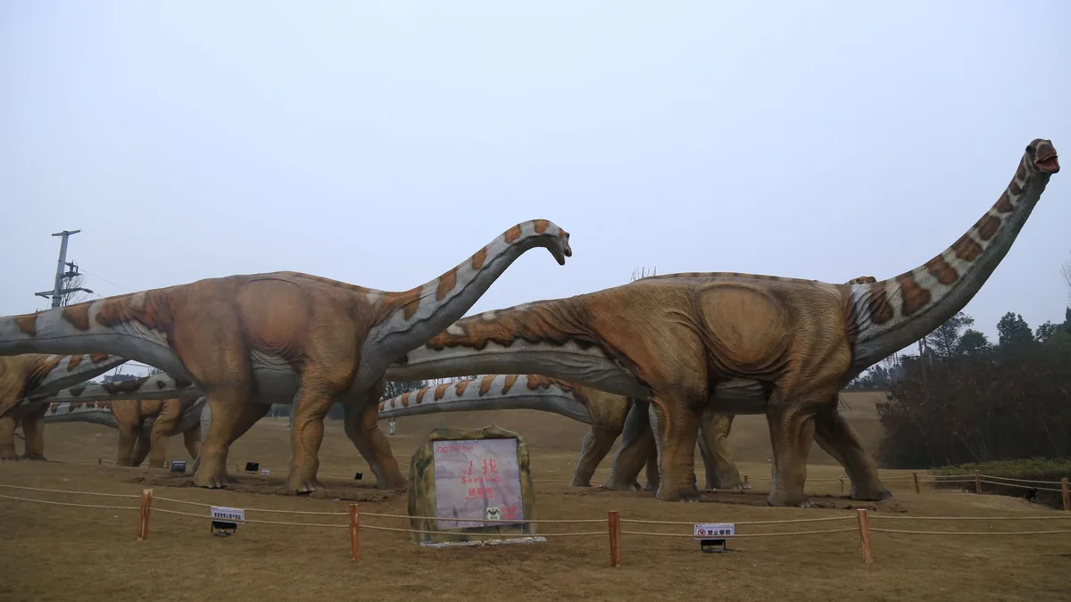 Life-size animatronic Apatosaurus long-neck dinosaur on outdoor exhibit