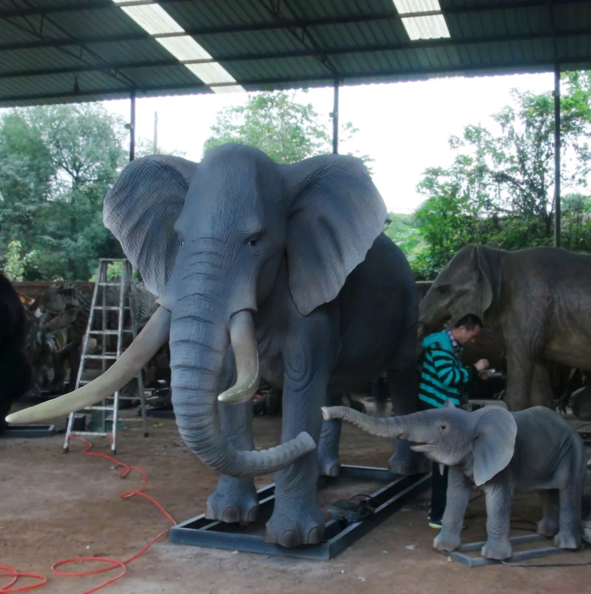 Animatronic baby elephant ride unit shown from the front with the trunk raised