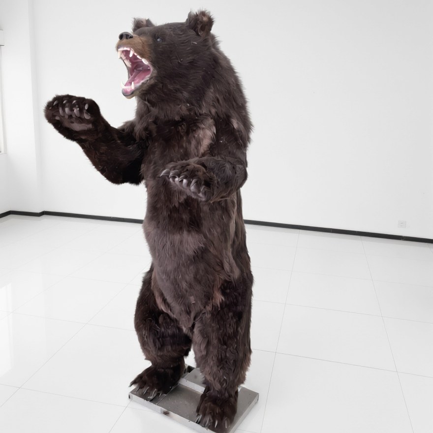 Life-size animatronic brown bear rearing and roaring with open jaw in a workshop setting