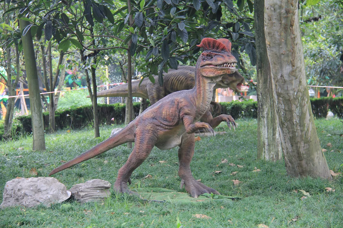 Dilophosaurus ride unit in a park with the twin crests clearly visible above the eyes