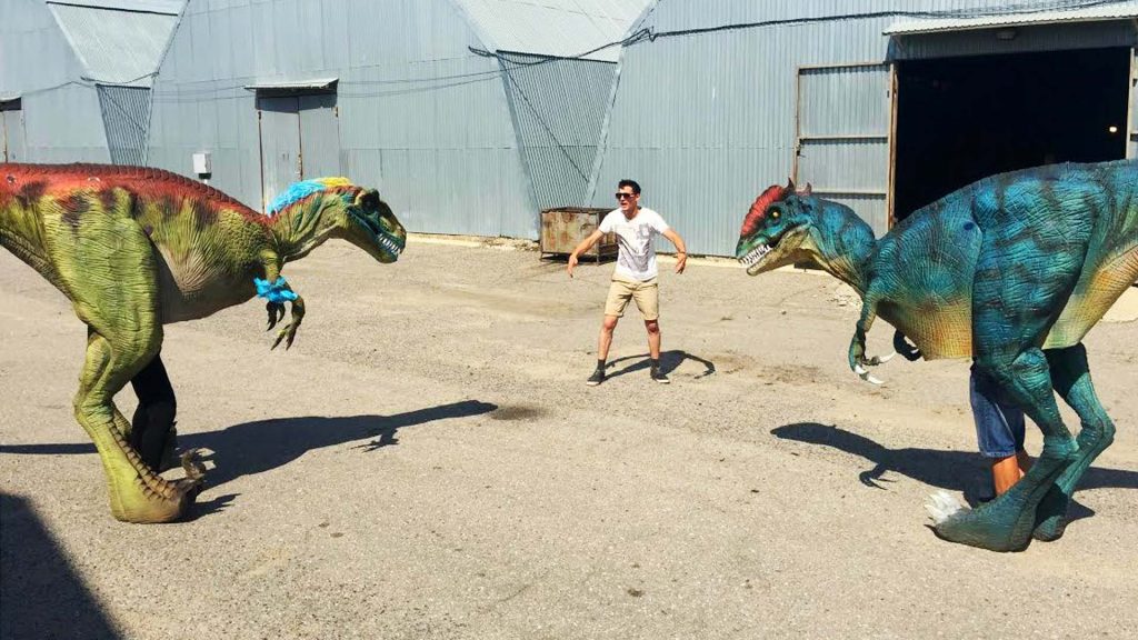 Two animatronic dinosaur costumes in green and blue tested side by side in our factory yard