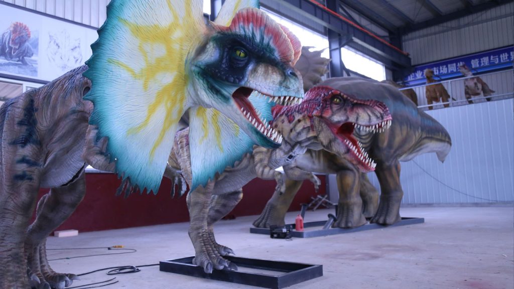Full view of a life-size animatronic Spinosaurus with a tall back sail in a factory workshop