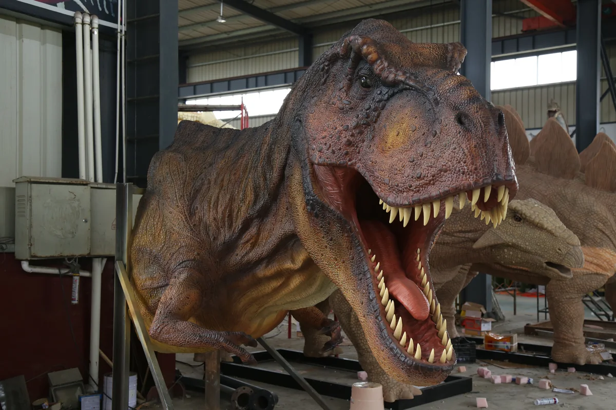 Interactive gesture-controlled animatronic T-Rex with motion sensor technology installed in its body for visitor-responsive roaring head movement