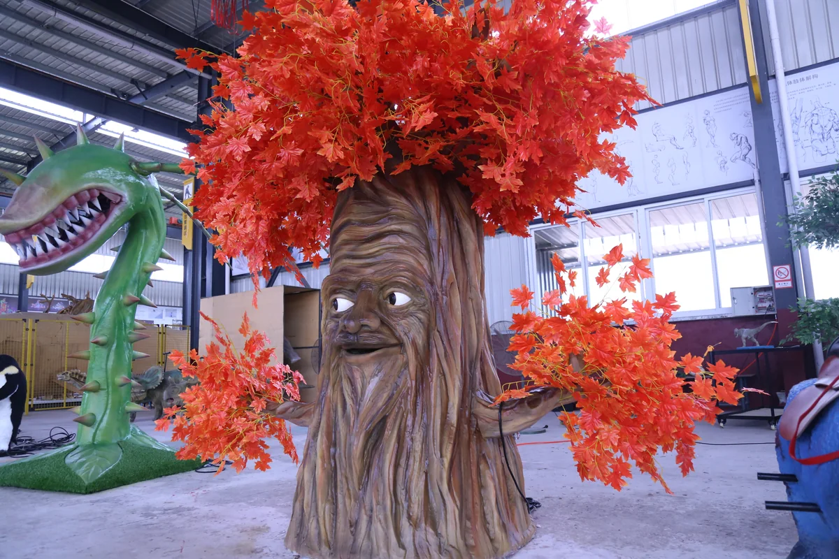 Interactive animatronic talking tree character with a friendly face and orange maple leaves in a theme park storytelling zone