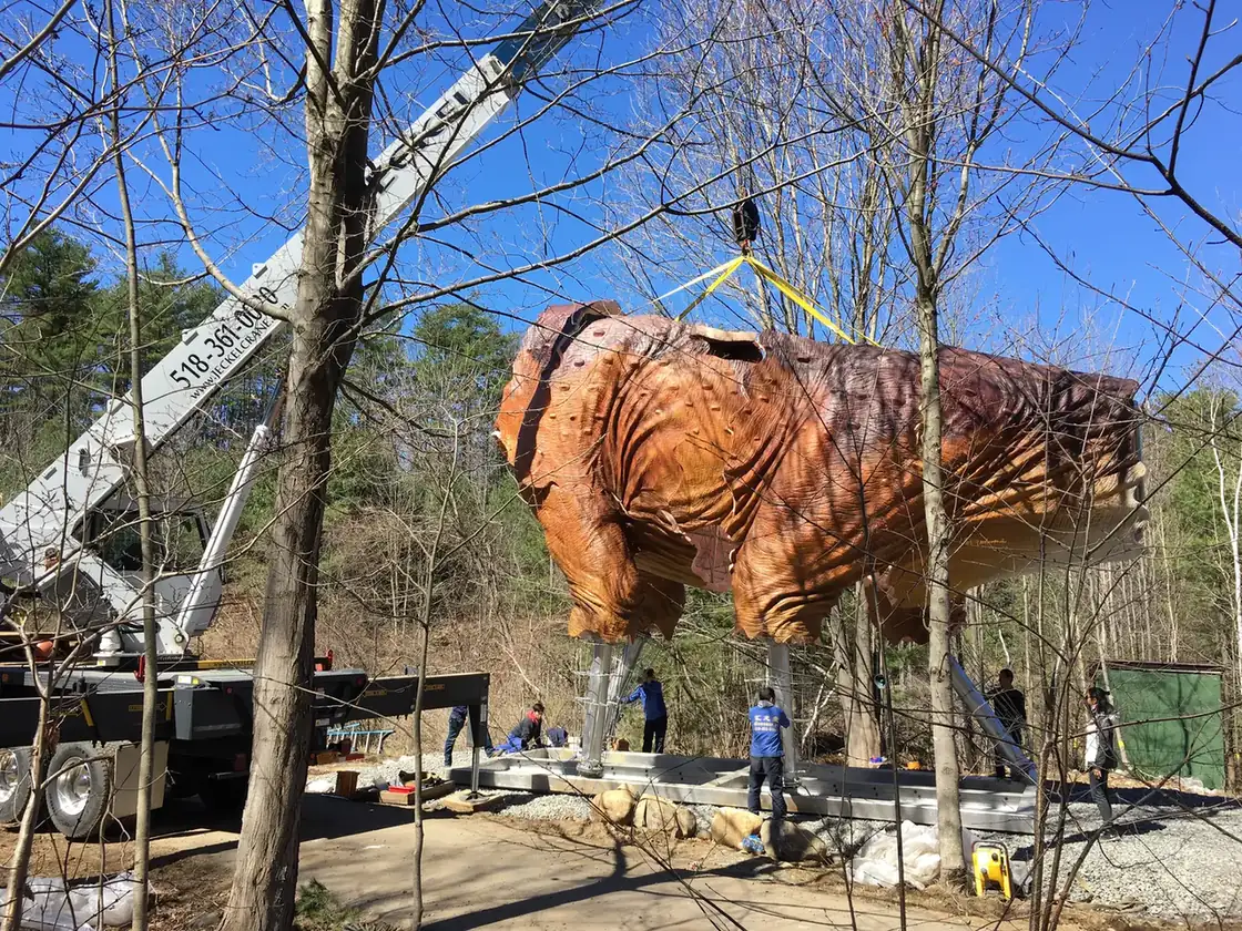 Crane holding a finished animatronic theropod body during installation