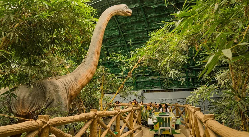 Ride-on animatronic dinosaurs at a dinosaur park gate zone