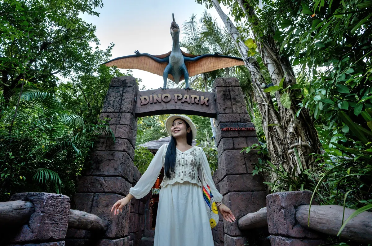 Multi-figure animatronic dinosaur scene in a theme park