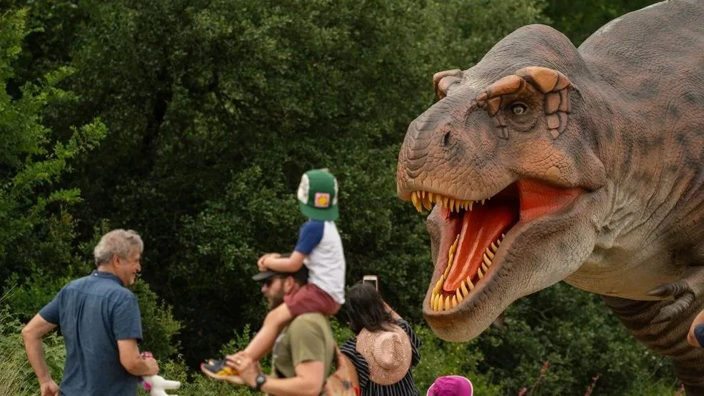 Visitors watching an open-jawed animatronic T-Rex at close range