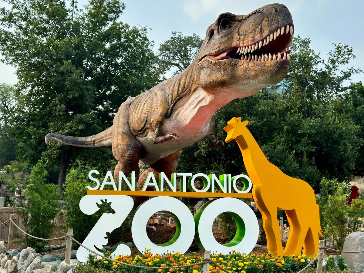 Zoo animatronic animals exhibit set among trees and landscaping